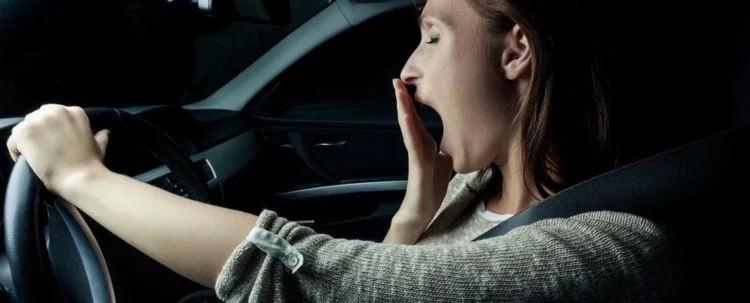 Zmęczenie za kierownicą – ziewająca kobieta w samochodzie – mytracko.pl